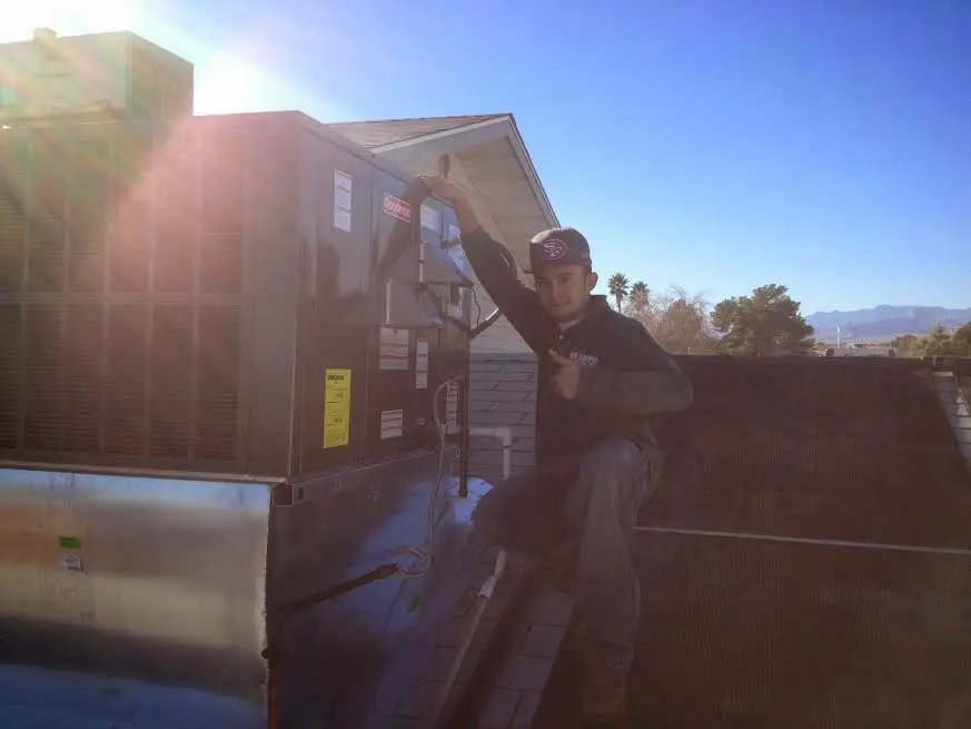HVAC technician performing HVAC Inspection on a rooftop unit in Sandown